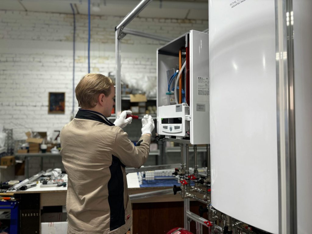 Ein Techniker inspiziert und repariert ein Heizsystem in einer industriellen Werkstattumgebung.